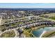 An aerial view showcases residential neighborhood with pond, manicured lawns, and a grid street layout at 12729 Brandenburg Dr, Carmel, IN 46032