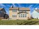 Beautiful backyard featuring a lush lawn, mature trees, and the home's exterior with large windows and neutral siding at 12729 Brandenburg Dr, Carmel, IN 46032