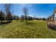 Lush backyard with verdant lawn, mature trees, and charming neighborhood views on a sunny day, perfect for outdoor activities at 12729 Brandenburg Dr, Carmel, IN 46032