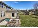 Expansive backyard featuring a stone patio with seating, a built-in grill, and lush green lawn at 12729 Brandenburg Dr, Carmel, IN 46032