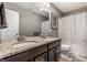 Bathroom with double sink vanity featuring granite countertops and dark wood cabinets at 12729 Brandenburg Dr, Carmel, IN 46032