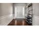 Bright foyer featuring hardwood floors, wainscoting, and a modern coat rack, leading into the home at 12729 Brandenburg Dr, Carmel, IN 46032