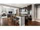 Open kitchen with breakfast bar, granite counters, stainless appliances, and wood floors at 12729 Brandenburg Dr, Carmel, IN 46032