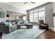 Open-concept living room with large windows, a plush sectional, and a view into the kitchen and dining area at 12729 Brandenburg Dr, Carmel, IN 46032