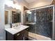 This bathroom features a dark vanity, a sliding glass shower, and decorative tile at 1334 E Market St, Indianapolis, IN 46202