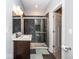 Bathroom features a dark vanity, a sliding glass shower, and decorative tile at 1334 E Market St, Indianapolis, IN 46202