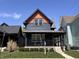 Beautiful two-story home with blue siding, a dark trim, an orange gable, and a covered front porch on a sunny day at 1334 E Market St, Indianapolis, IN 46202