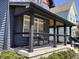 Inviting front porch features a seating area, modern railings, dark wood trim, and a wood ceiling at 1334 E Market St, Indianapolis, IN 46202
