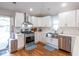 Well-lit kitchen featuring stainless steel appliances, white cabinets, and hardwood floors at 1334 E Market St, Indianapolis, IN 46202