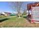 Spacious backyard with green grass, large tree, shed, and pergola-covered patio area at 1360 Evergreen Dr, Greenfield, IN 46140
