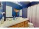 Bathroom with a large mirror, wood cabinets, and a shower with a white and purple curtain at 1360 Evergreen Dr, Greenfield, IN 46140