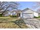 Charming single-story home with a well-maintained lawn, attached garage, and beautiful curb appeal on a sunny day at 1360 Evergreen Dr, Greenfield, IN 46140