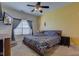 Bright bedroom with ceiling fan, large window, and floral bedding at 1360 Evergreen Dr, Greenfield, IN 46140