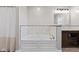 Elegant bathroom featuring a soaking tub with tile accent wall, vanity with wooden cabinets, and neutral paint at 139 W Jefferson St, Jamestown, IN 46147