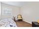 Simple bedroom with a single bed, side table, chair, and a small window at 139 W Jefferson St, Jamestown, IN 46147