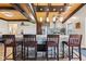 Open kitchen area with a large stone-accented center island with barstool seating, stainless steel appliances, and wood ceiling at 139 W Jefferson St, Jamestown, IN 46147