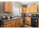 A cozy kitchenette featuring wood cabinets, dark countertops, black mini refrigerator and stainless steel sink at 139 W Jefferson St, Jamestown, IN 46147