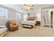 The cozy bedroom offers a ceiling fan, neutral walls, patterned carpet, and staircase access, for peaceful retreat at 139 W Jefferson St, Jamestown, IN 46147