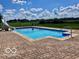 Inviting backyard pool with a slide surrounded by a beautifully designed stone patio and lush green landscape at 139 W Jefferson St, Jamestown, IN 46147