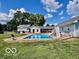 Spacious backyard featuring a pool, slide, well-maintained lawn, and picturesque landscaping at 139 W Jefferson St, Jamestown, IN 46147