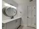 Elegant bathroom featuring a gray vanity, round mirror, and contemporary lighting at 14402 Allison Dr, Carmel, IN 46033