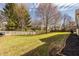 A spacious backyard with a manicured lawn, mature trees, and a white picket fence at 1448 Sedona Dr, Carmel, IN 46032
