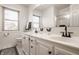 Bright bathroom featuring double vanity, modern fixtures, neutral tile, and a shower behind glass doors at 1448 Sedona Dr, Carmel, IN 46032