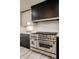 The kitchen features stainless steel Zline oven, white subway tile backsplash, dark cabinets and light wood flooring at 1448 Sedona Dr, Carmel, IN 46032