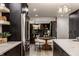 Open kitchen with marble counters flows into dining area, featuring stainless steel fridge and modern pendant lighting at 1448 Sedona Dr, Carmel, IN 46032