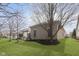 Beautiful backyard with green grass, landscaping, and a partial view of the brick house at 15254 Kampen Cir, Carmel, IN 46033