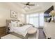 Bright bedroom with a tufted headboard, a ceiling fan, hardwood floors, and natural light at 15254 Kampen Cir, Carmel, IN 46033