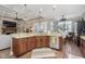 Open-concept kitchen featuring granite countertops, dark wood cabinets, and stainless appliances at 15254 Kampen Cir, Carmel, IN 46033