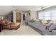 Living room with a large gray sectional sofa, a leather chair, and a hallway view at 15254 Kampen Cir, Carmel, IN 46033