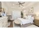 Serene main bedroom with soft colors, plush bedding, ample natural light, and an elegant ceiling fan at 15254 Kampen Cir, Carmel, IN 46033