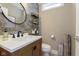 Stylish powder room with modern vanity, decorative wall accents, and a sleek round mirror at 15254 Kampen Cir, Carmel, IN 46033