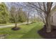 Beautifully landscaped yard with mature trees and lush green grass, creating a park-like setting at 15254 Kampen Cir, Carmel, IN 46033