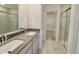 Bright modern bathroom featuring double sinks, grey counters and a glass-enclosed shower at 15925 Cobbs Crk Ln, Noblesville, IN 46060