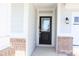 Covered front porch with brick columns and a stylish front door at 15925 Cobbs Crk Ln, Noblesville, IN 46060