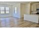 Bright, open-concept living room with wood floors and view of modern kitchen at 15925 Cobbs Crk Ln, Noblesville, IN 46060