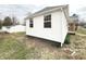 Side exterior view showing the home's white siding and yard at 1640 W 7Th St, Anderson, IN 46016