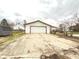 Wide angle view of detached garage with white door and concrete drive at 1640 W 7Th St, Anderson, IN 46016