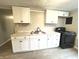 Updated kitchen features white cabinets, modern black hardware, marble-look countertops, and a black stove at 1640 W 7Th St, Anderson, IN 46016