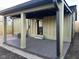 A covered back porch with wooden flooring, a ceiling fan, and steps down to a gravel area at 1716 E Kelly St, Indianapolis, IN 46203