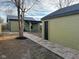 A backyard with a brick and gravel walkway that leads to the house, along with a garage with a modern door at 1716 E Kelly St, Indianapolis, IN 46203