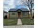Charming home with a metal roof, wood fence, grassy yard, and welcoming walkway at 1716 E Kelly St, Indianapolis, IN 46203