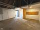The empty garage has white brick walls, a concrete floor, and a single door exit to the back of the home at 1716 E Kelly St, Indianapolis, IN 46203