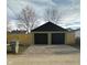 A two car detached garage with black doors sits behind a wooden fence at 1716 E Kelly St, Indianapolis, IN 46203