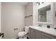 Bathroom with marble countertop, decorative mirror, gray vanity, toilet and chrome hardware at 17918 Lucas Cir, Westfield, IN 46074