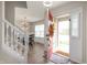 Inviting entryway with a view of the staircase and dining area featuring modern light fixture at 17918 Lucas Cir, Westfield, IN 46074
