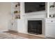 Bright living room featuring a fireplace with white mantel, built-in shelves, and hardwood floors at 17918 Lucas Cir, Westfield, IN 46074